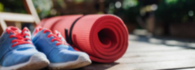 Imagem de um par de tênis azul e um tapete de yoga vermelho